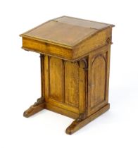 A 19thC oak Davenport with a leather inset writing slope above a panelled front and sides with