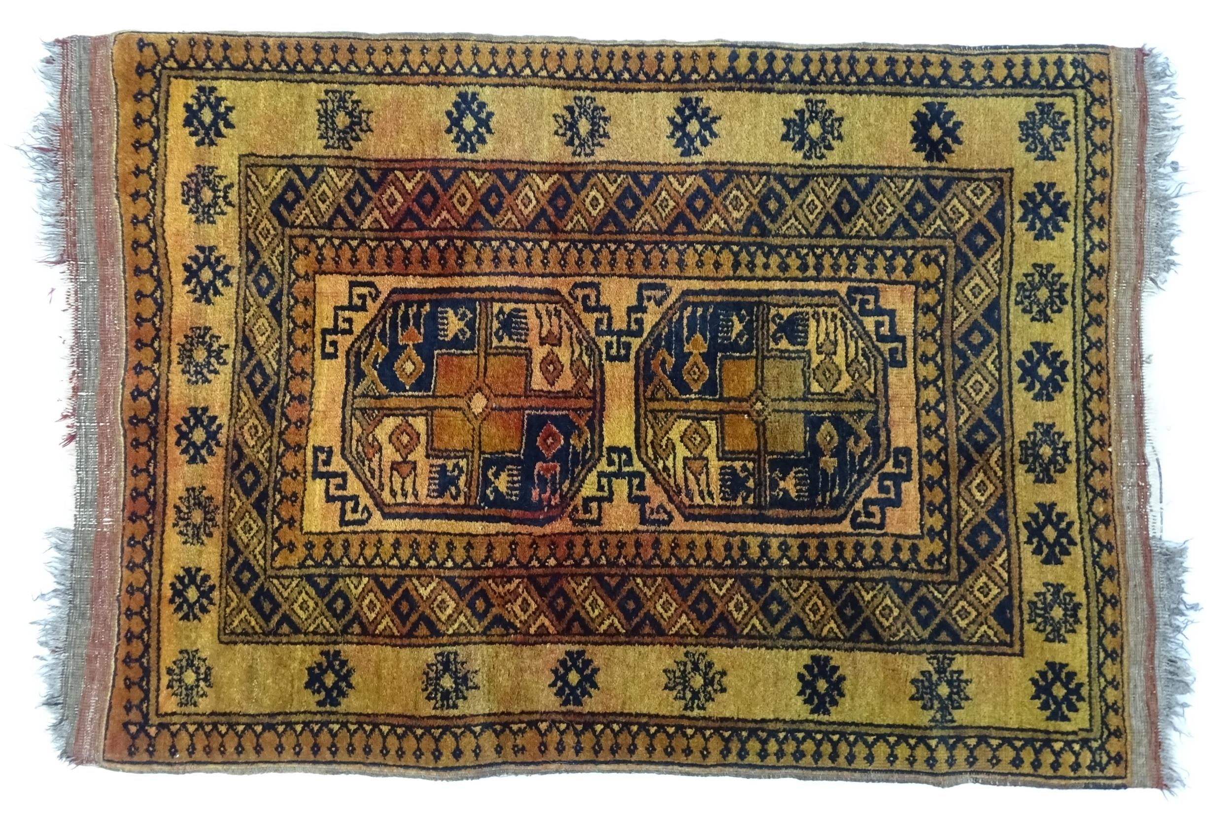 Carpet / Rug: An ochre ground rug decorated with centre vignettes with geometric motifs, further