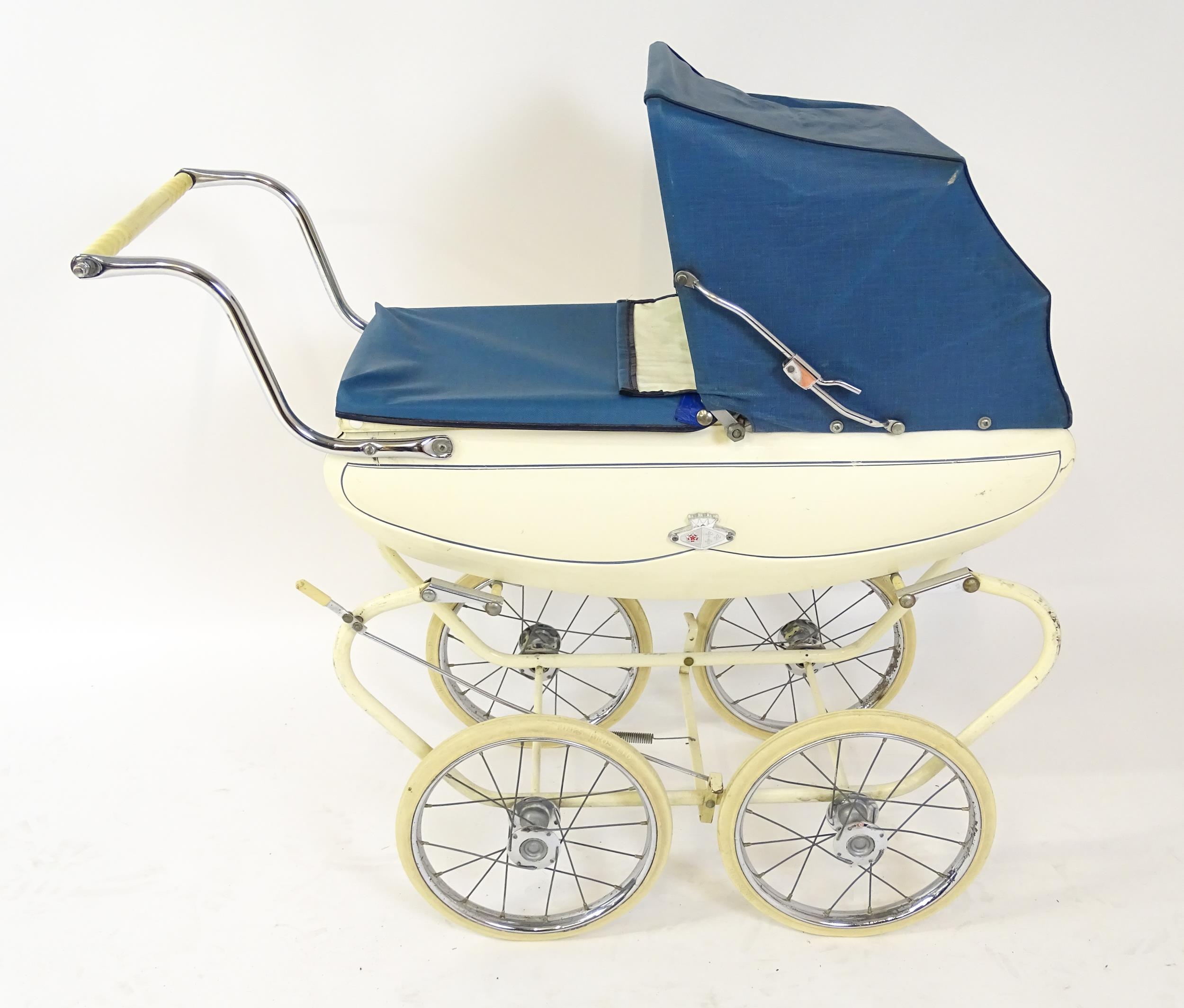 Toys: A 20thC Pedigree dolls pram with cream exterior and blue hood. Together with a plastic doll - Image 7 of 11