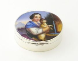 A silver pill box with gilded interior and ceramic cabochon to lid depicting a young girl holding