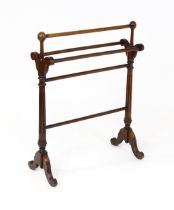 An early 20thC mahogany towel rail with five turned cross rails raised on fluted supports and