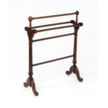 An early 20thC mahogany towel rail with five turned cross rails raised on fluted supports and