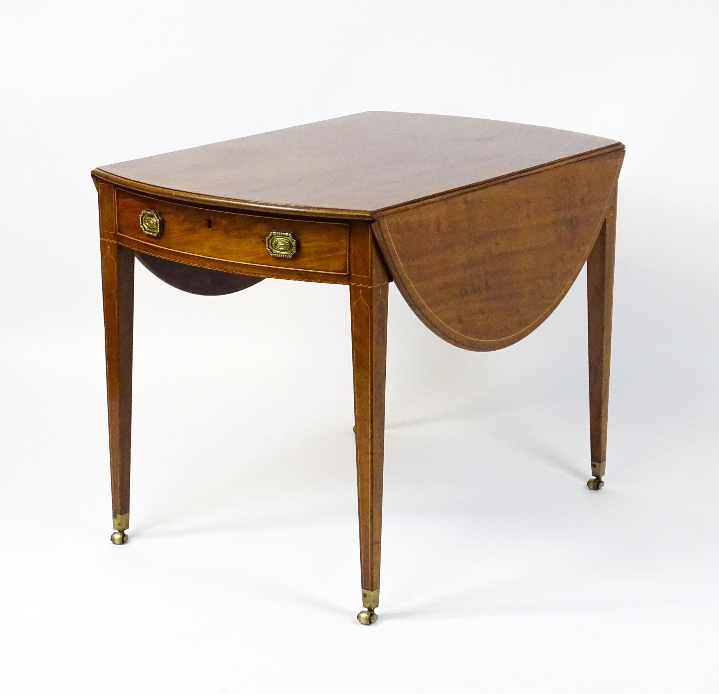 An early 19thC mahogany Pembroke table with a satinwood strung top above a single frieze drawer
