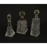 Three assorted cut glass scent / perfume bottles with silver mounts, to include one hallmarked