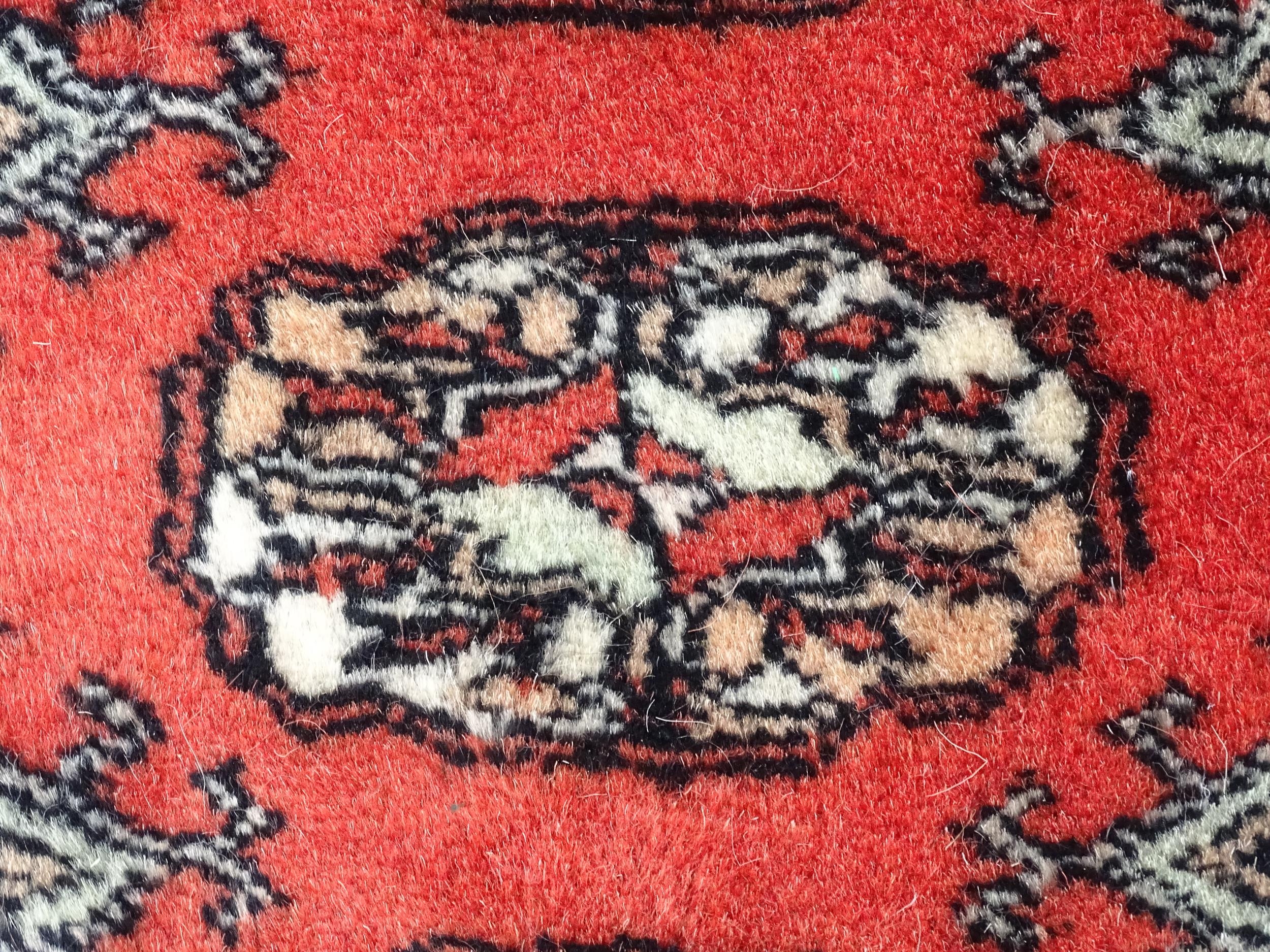 Carpet / Rug : A Pakistan wool red ground rug decorated with repeating geometric motifs with further - Image 7 of 8