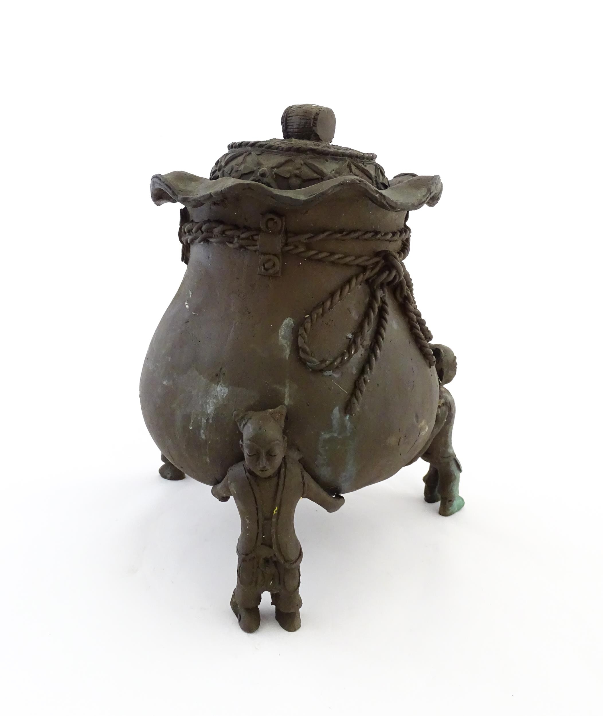 A Chinese cast bronze pot and cover modelled as a money bag with rope tie supported by three figural - Image 7 of 10