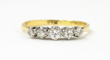 An 18ct gold ring set with five graduated diamonds. Ring size approx. R Please Note - we do not make