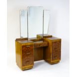 A mid 20thC Art Deco style burr walnut veneered dressing table with a triptych mirror above a