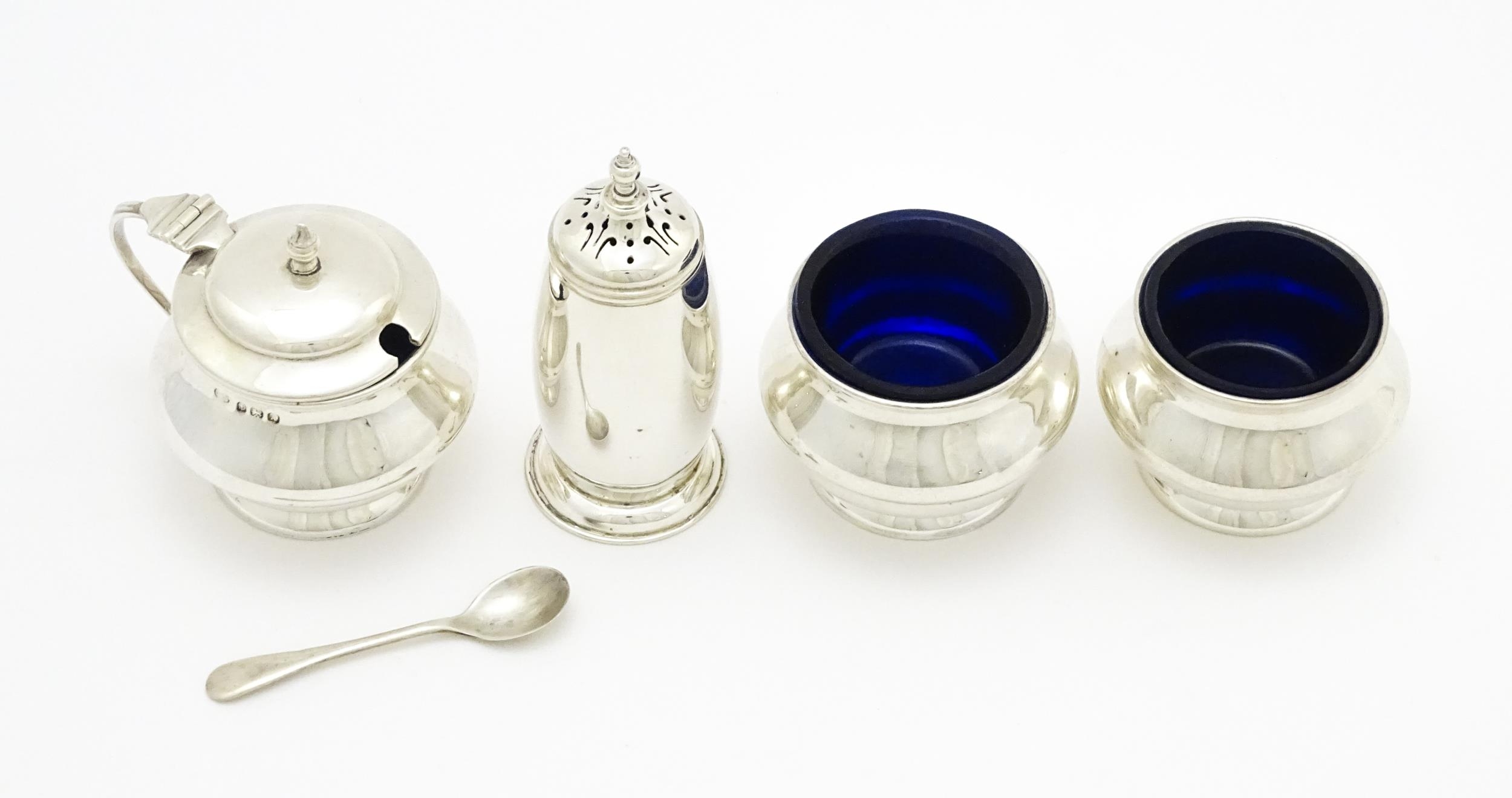 A matched four piece silver cruet set comprising pepper, mustard with spoon and two salts with