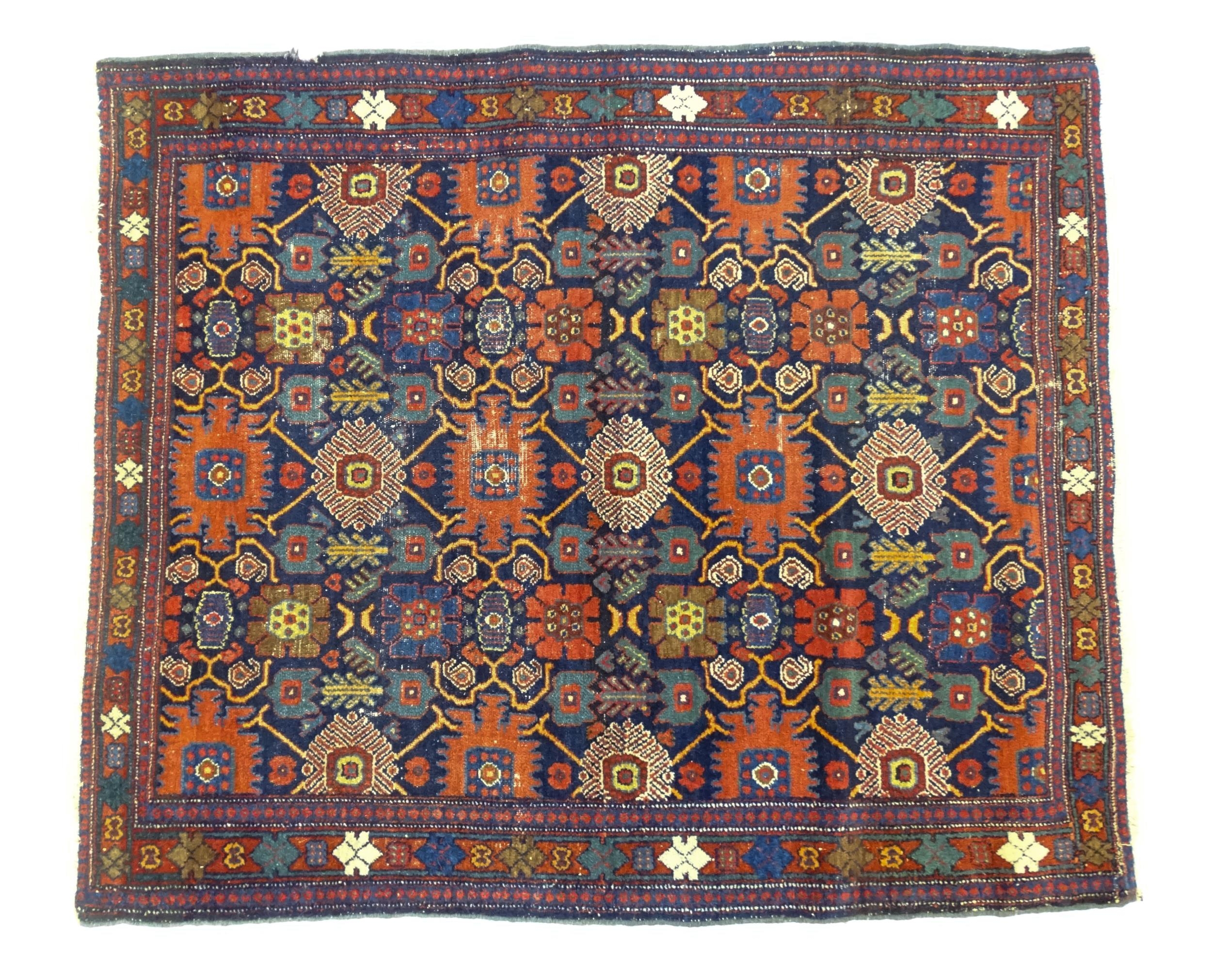 Carpet / Rug: A blue ground rug decorated with repeating geometric motifs of stylised floral and