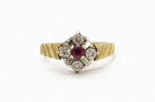 A 9ct gold ring set with central ruby bordered by four diamonds. Ring size approx. M Please Note -