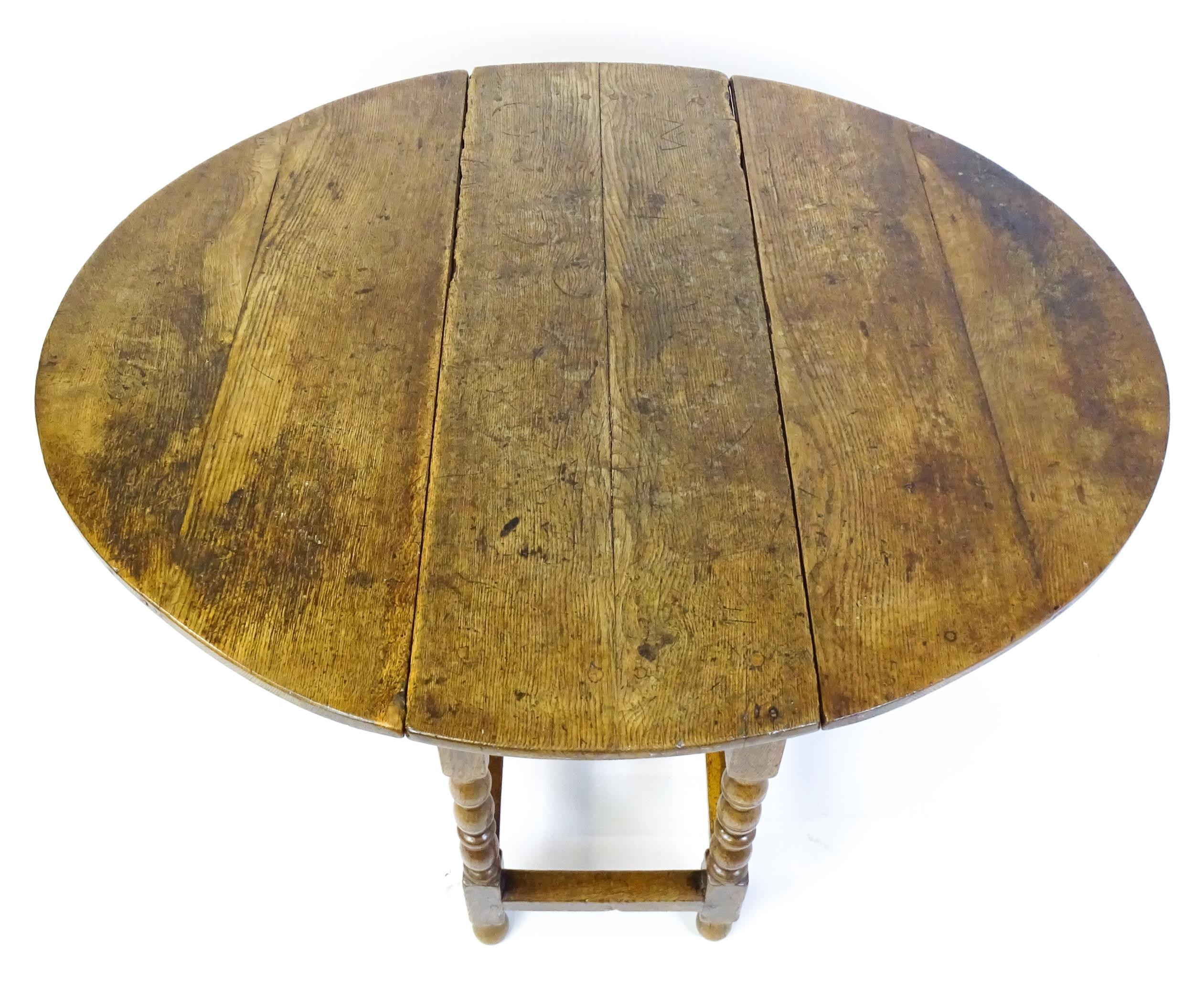 An early 18thC oak drop leaf table of large proportions, the table having two demi lune leaves and - Image 3 of 6