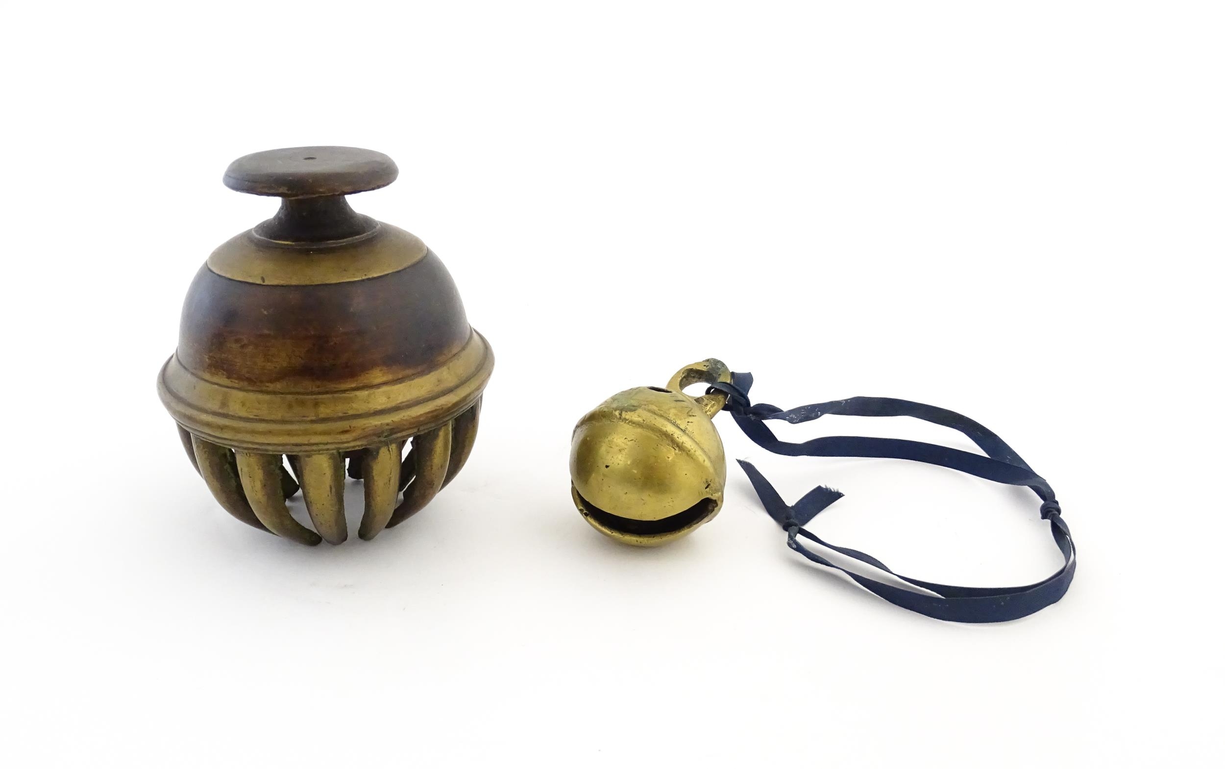 An Indian brass elephant claw bell. Together with a crotal bell marked AD and HN. Claw bell