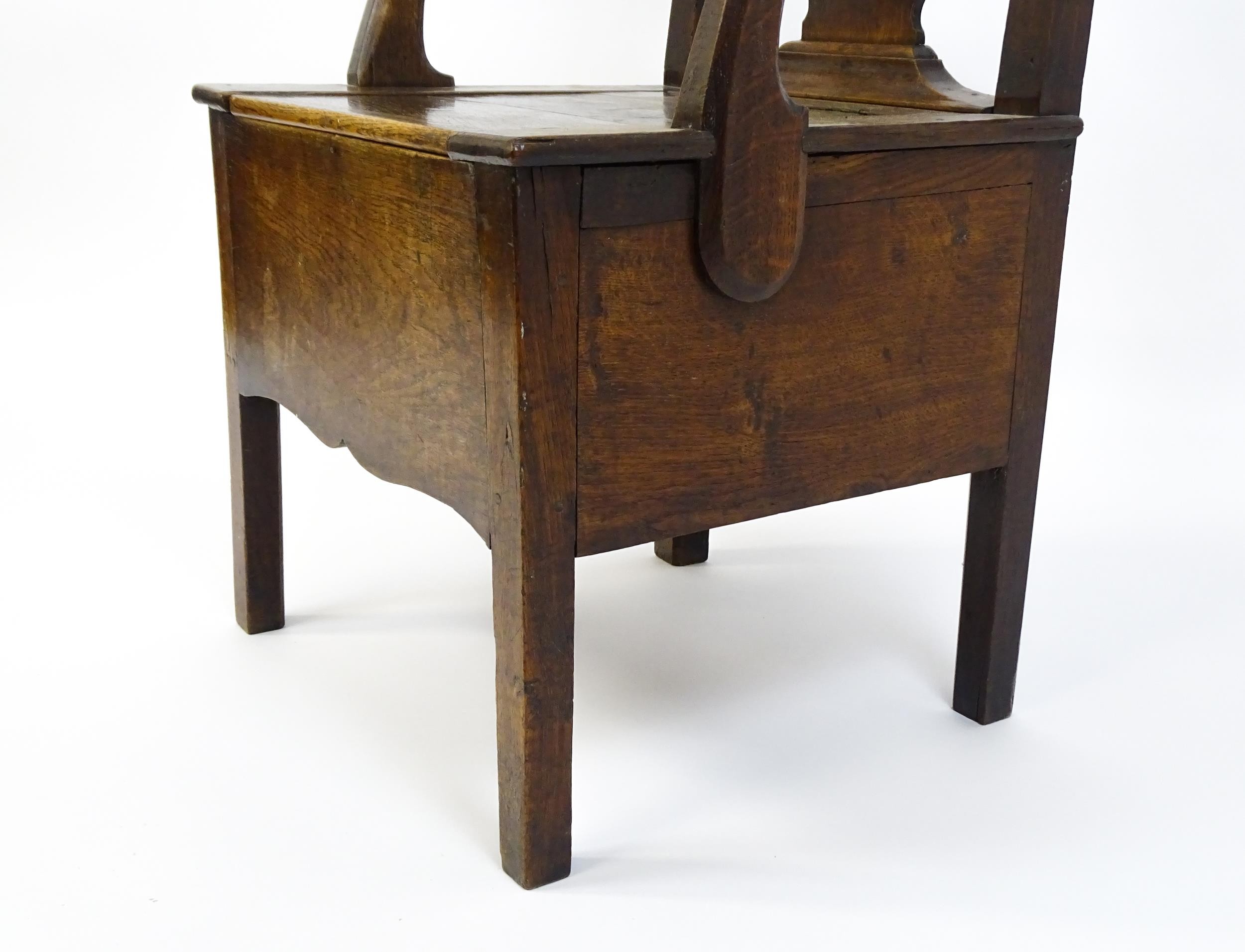 A late Georgian oak commode chair with a Chippendale style back splat above a hinged seat opening to - Image 8 of 10