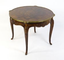 A Louis XV style centre table with a brass surround and a burr walnut veneered top above four carved
