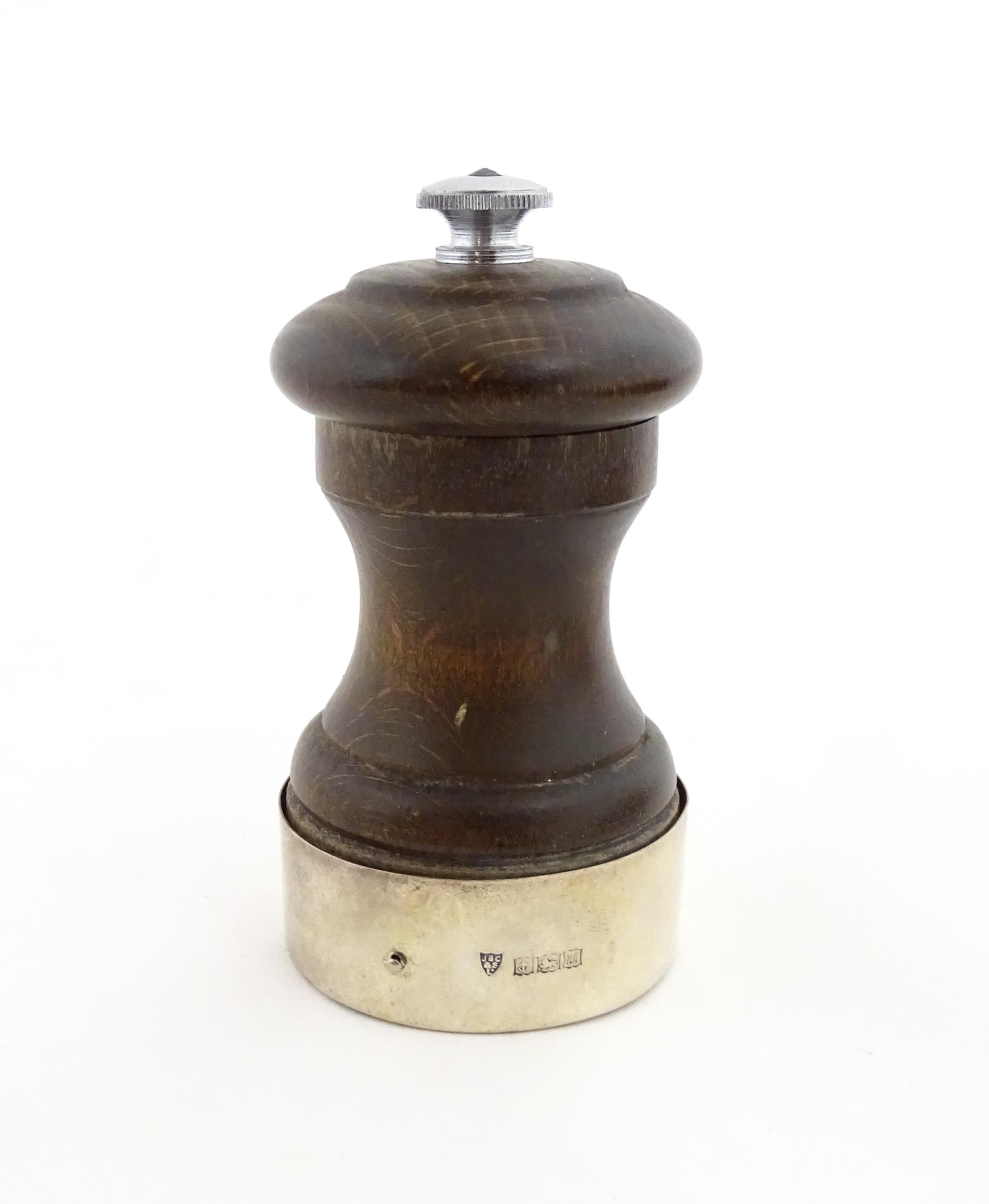 A 20thC turned wooden pepper mill / grinder with silver mount hallmarked Birmingham 1969, maker J.