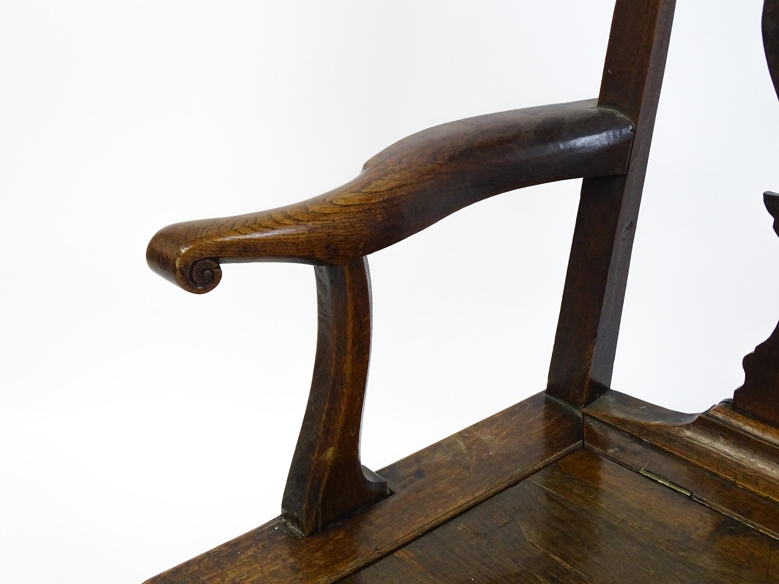A late Georgian oak commode chair with a Chippendale style back splat above a hinged seat opening to - Image 9 of 10
