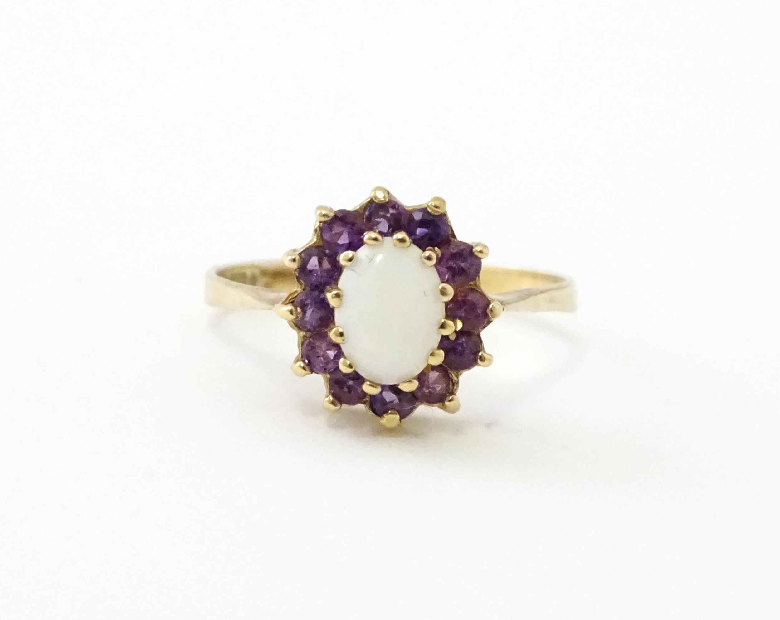 A 9ct gold ring set with central opal bordered by amethysts. Ring size approx. M Please Note - we do - Image 2 of 7