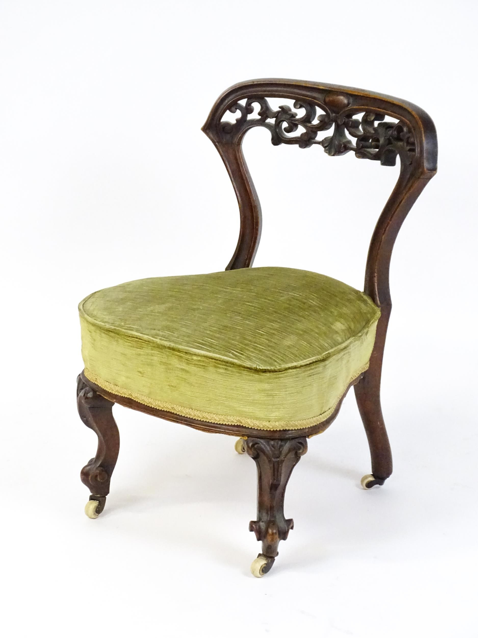 A mid / late 19thC mahogany nursing chair with a pierced, carved floral top rail above moulded - Image 5 of 6