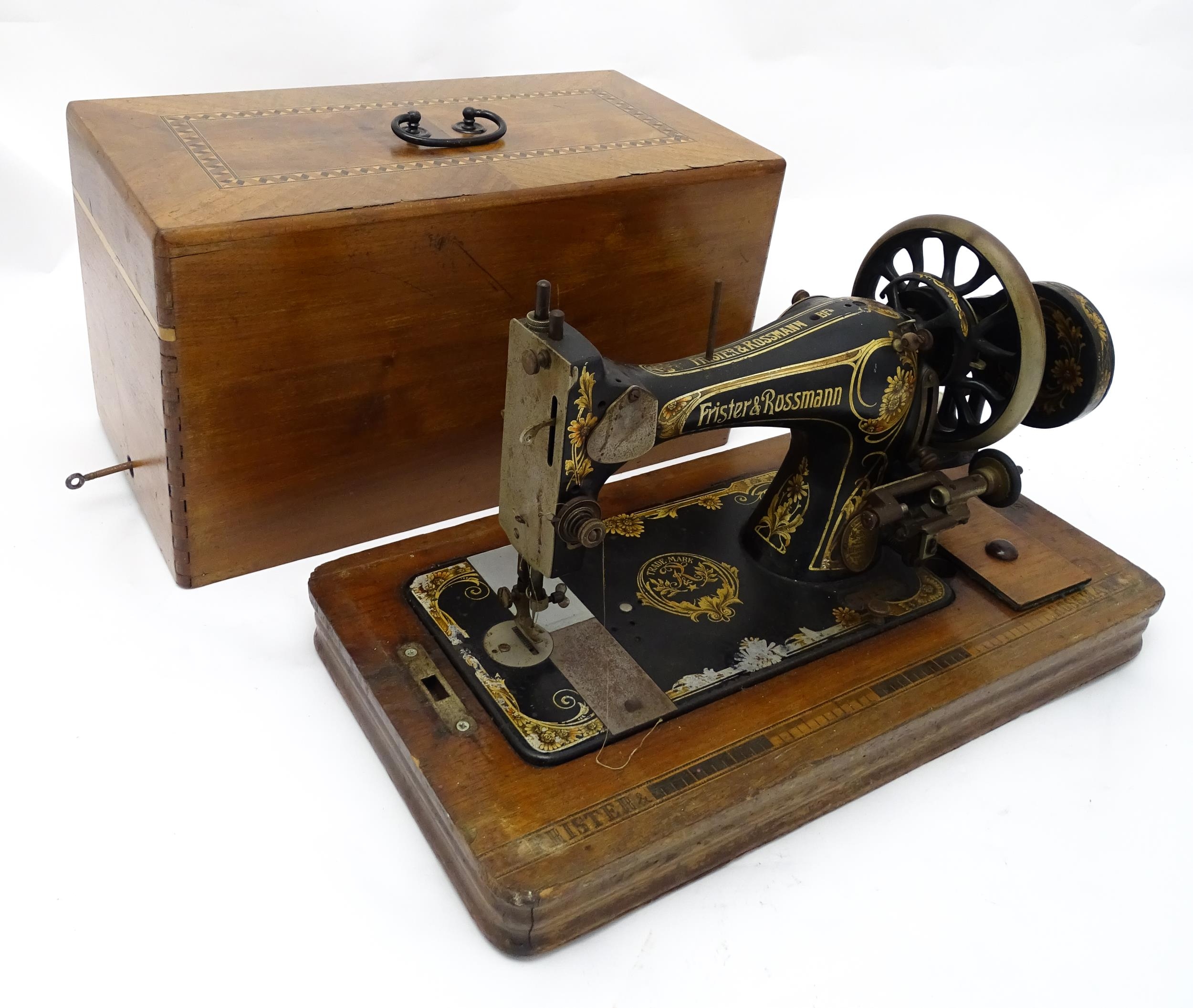 An early 20thC Frister & Rossmann hand crank sewing machine with floral and foliate decoration.