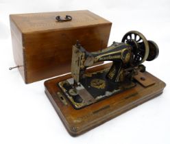 An early 20thC Frister & Rossmann hand crank sewing machine with floral and foliate decoration.