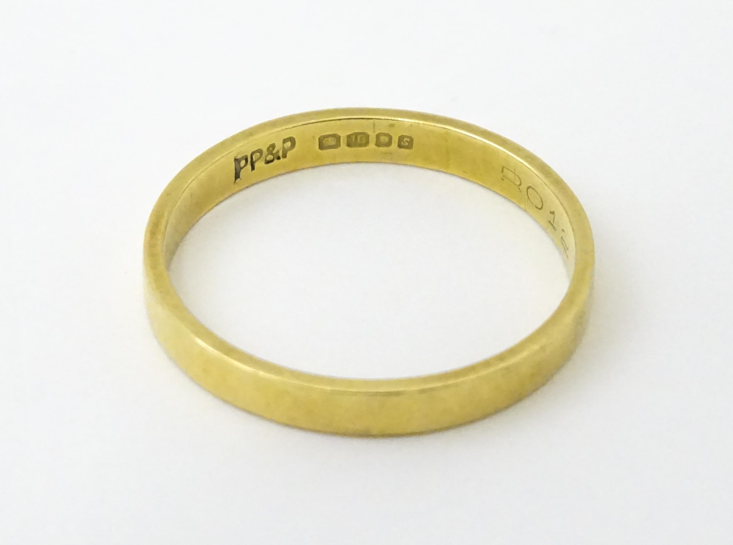 An 18ct gold ring / wedding band. Ring size approx. O Please Note - we do not make reference to