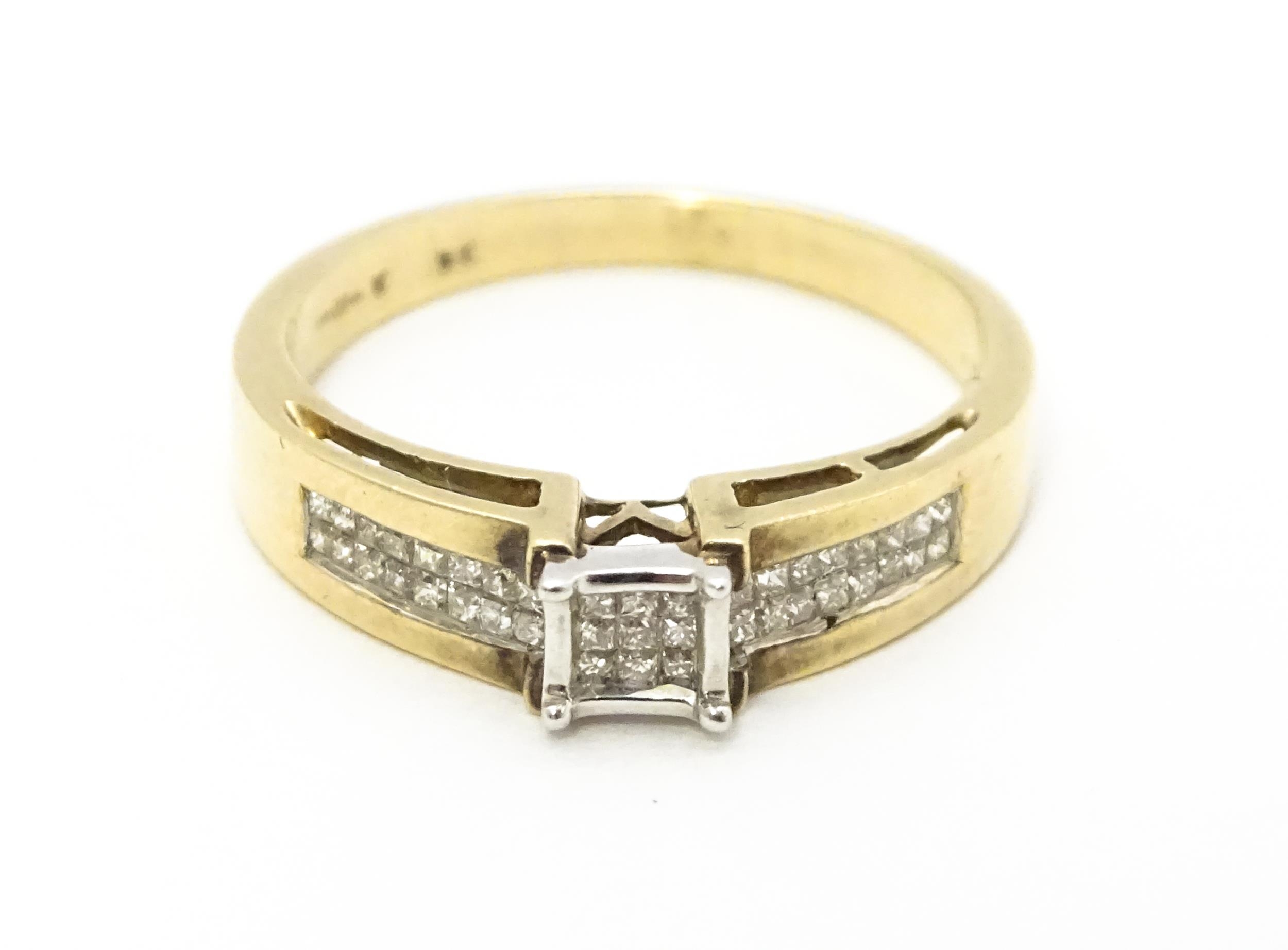 A 9ct gold ring set with 9 central diamonds flanked by a further 14 diamonds to each shoulder.