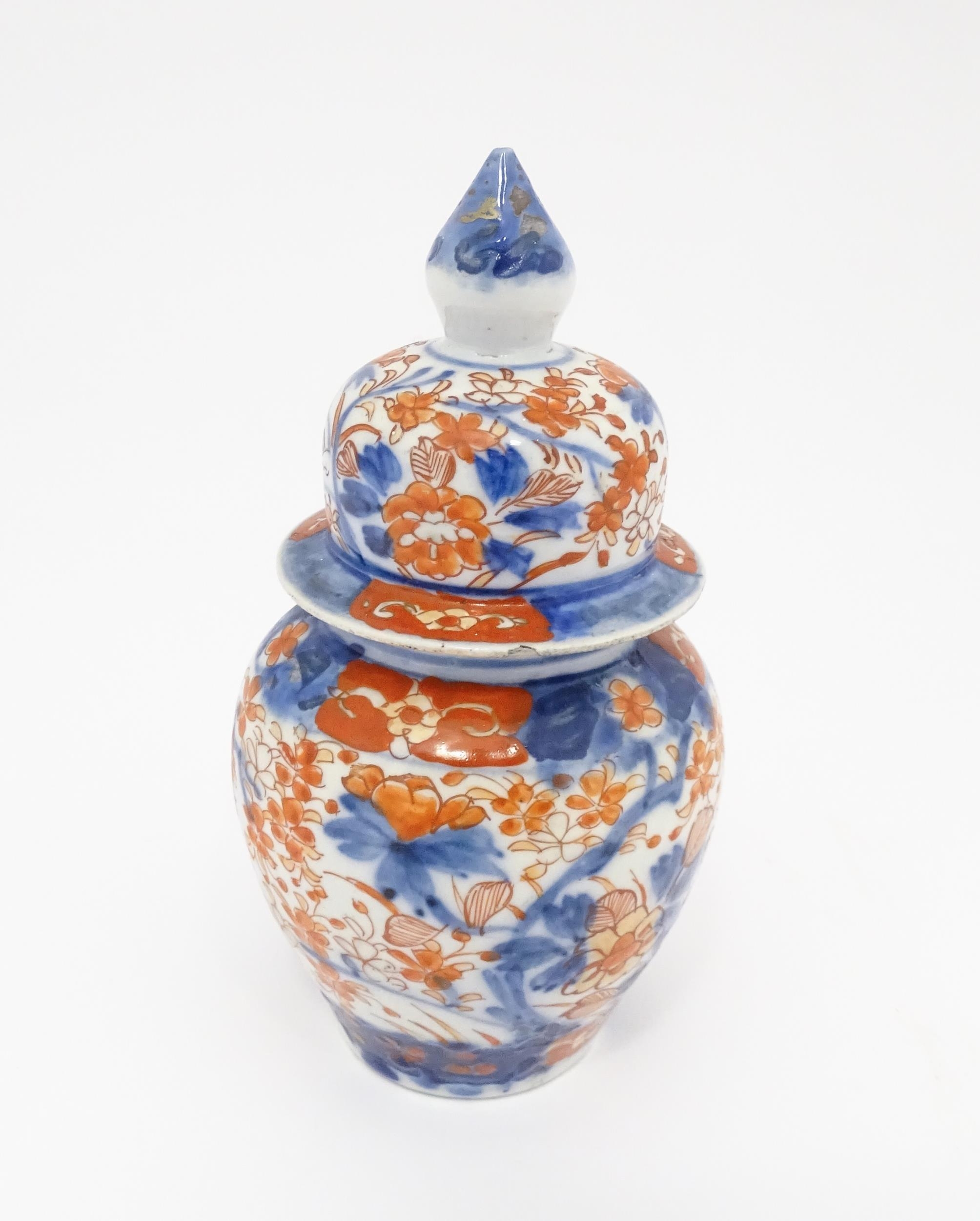 An Oriental ginger jar decorated in the Imari palette with flowers and foliage. Approx. 7 1/2"