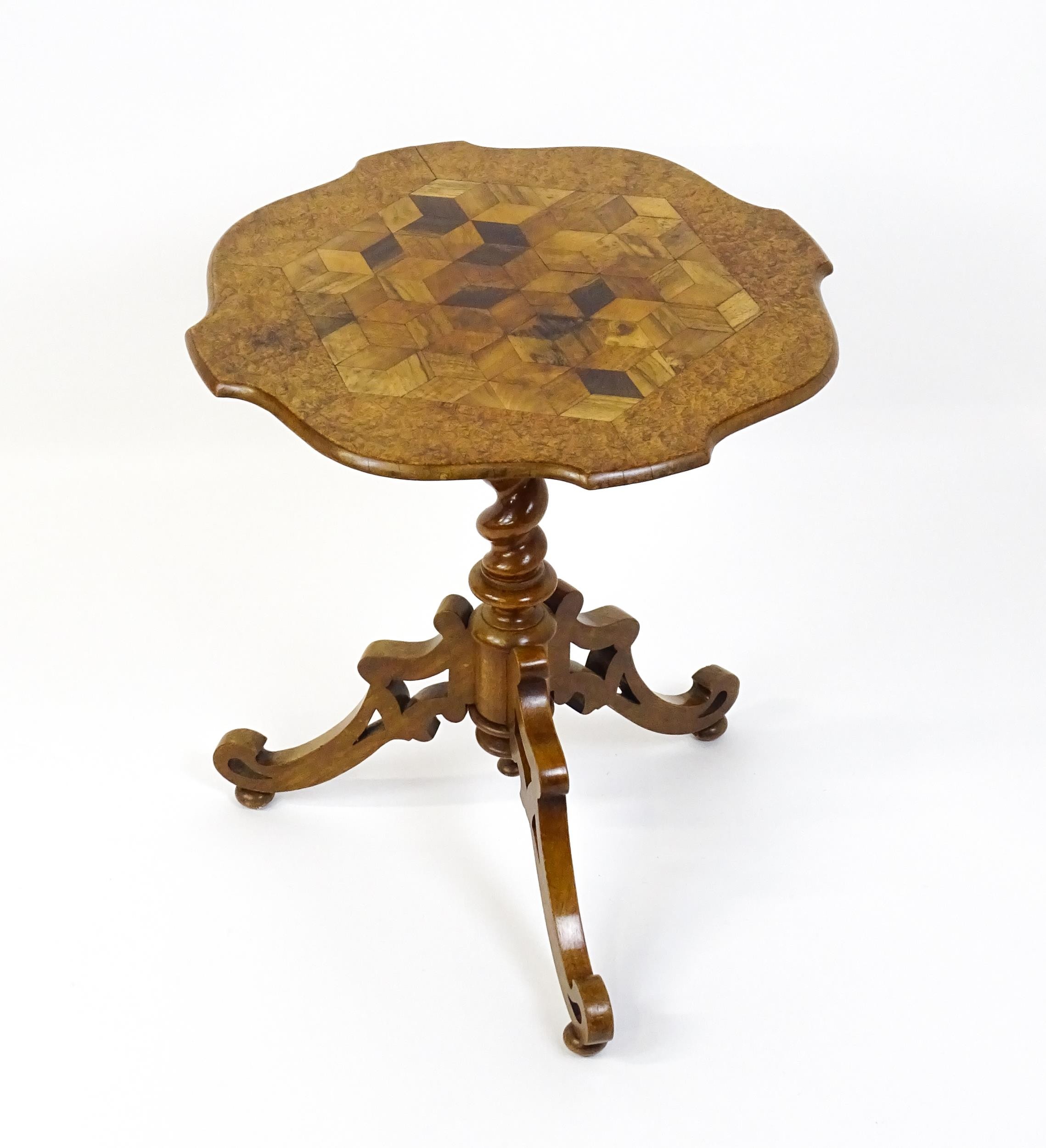 A 19thC tripod table with a burr amboyna veneered top surrounding a central parquetry style sample