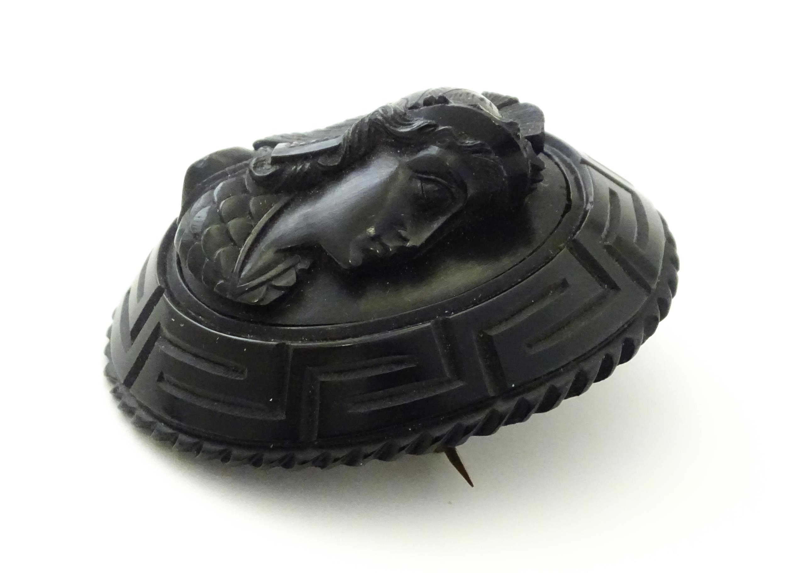 A Victorian Whitby jet cameo brooch depicting the head of a Roman solider, within a Greek key mount. - Image 3 of 7