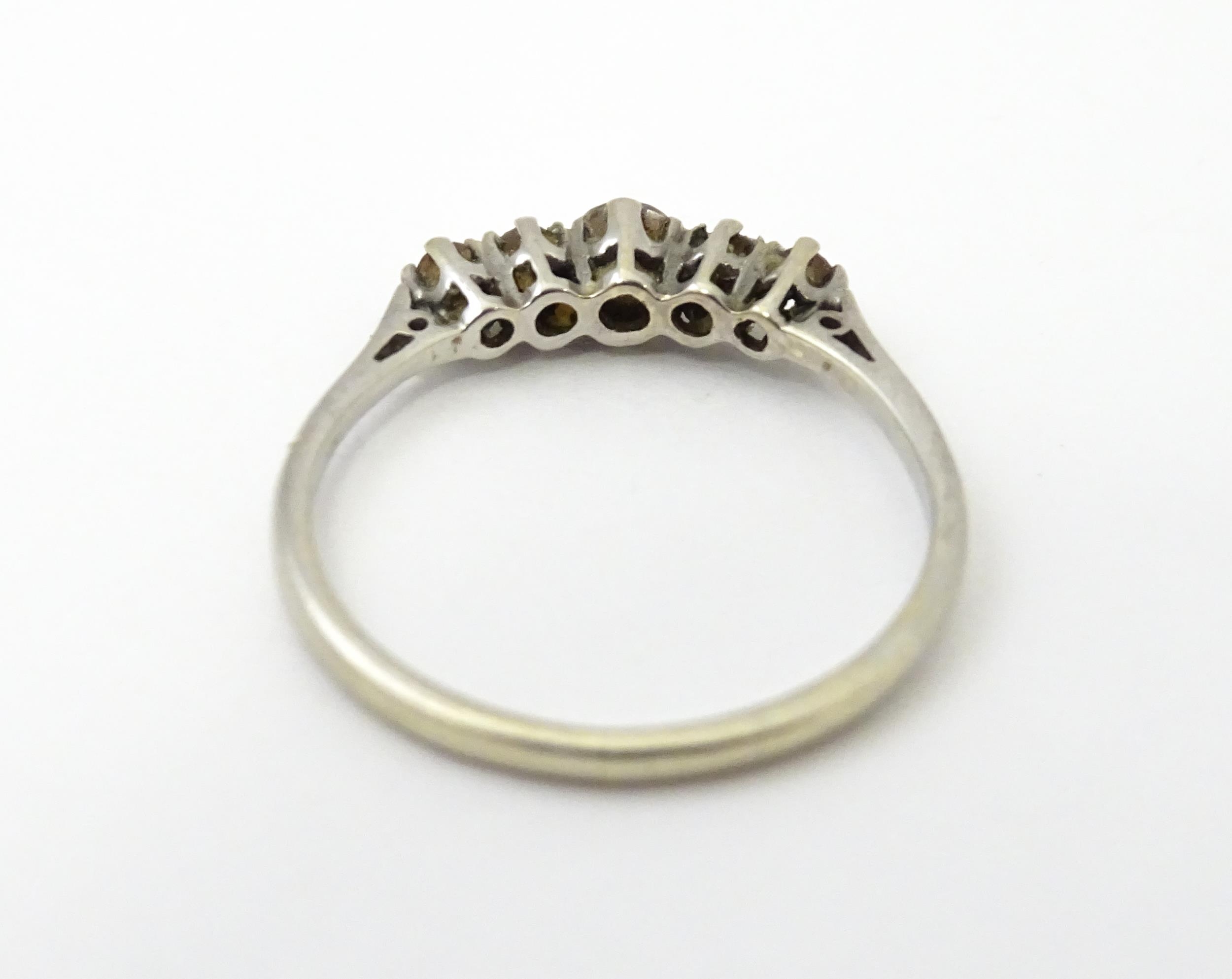 A white gold ring set with central brown diamond flanked by 4 further diamonds in a linear - Image 6 of 7