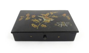 An early 20thC papier mache lacquered box of rectangular form decorated with a bird perched on a