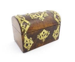 A 19thC walnut tea caddy of dome form with brass strapwork decoration and rivet detail, opening to