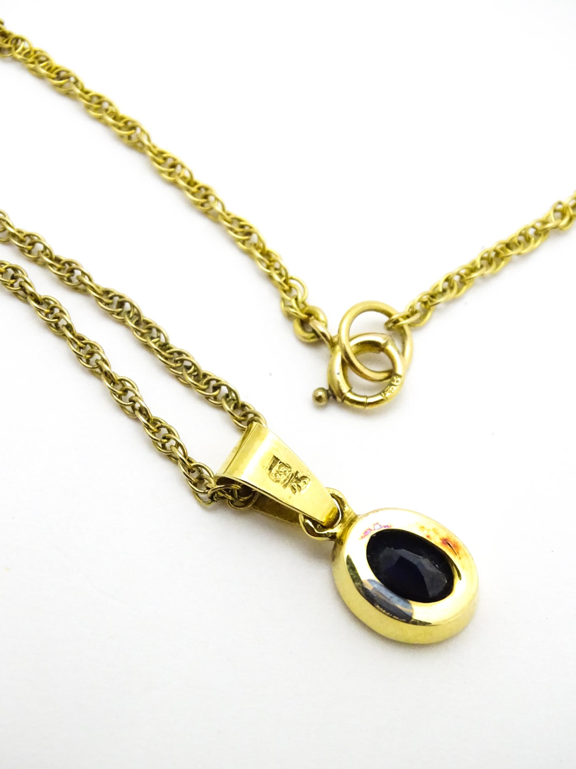 A yellow metal pendant set with central sapphire on a 9ct gold chain. Pendant approx. 1 3/4" long - Image 5 of 6