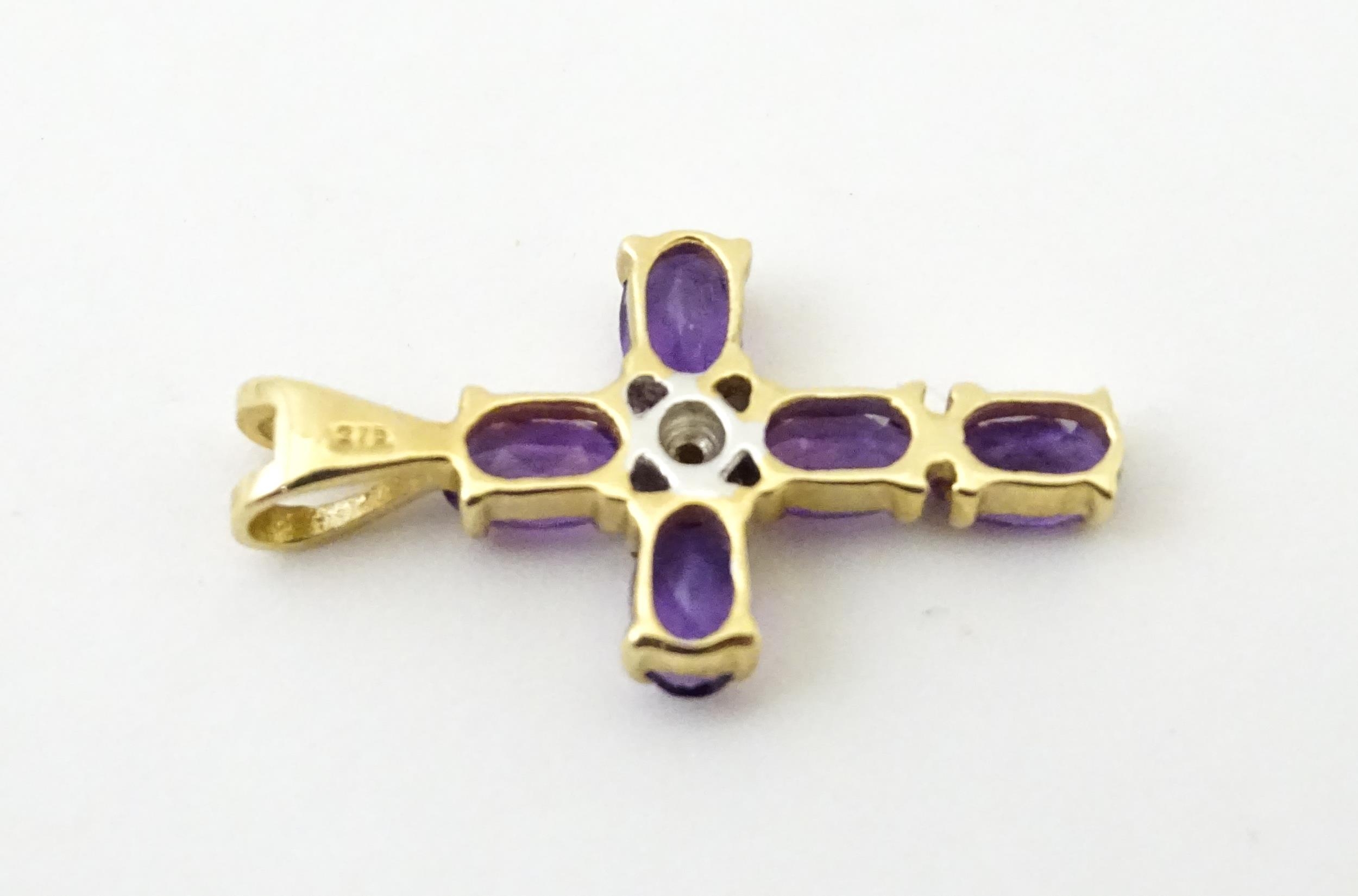 A 9ct gold cross formed pendant set with amethyst and central diamond. Approx. 1" long Please Note - - Image 6 of 6