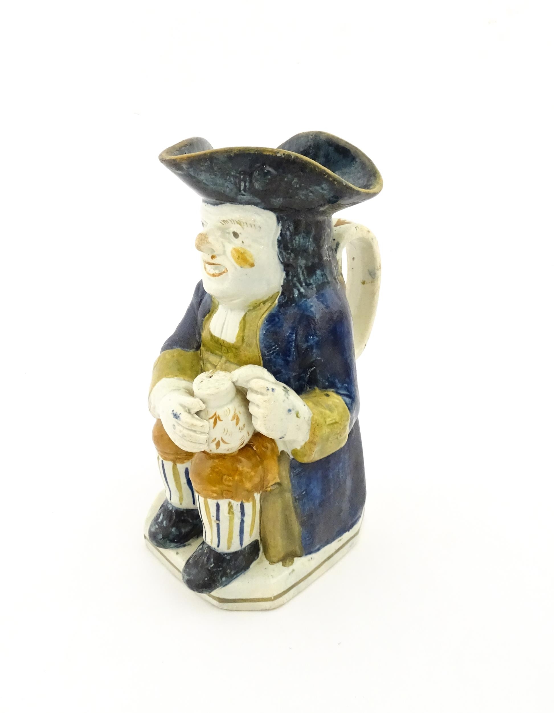 A 19thC Staffordshire pottery character Toby jug decorated in Pratt colours. Approx. 9 1/4" high