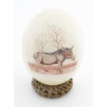 An ostrich egg with engraved decoration depicting a wild boar. Signed Fidelis lower right. Approx. 6