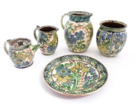 A quantity of studio pottery wares by Peter Thomas decorated with flowers and foliage, comprising