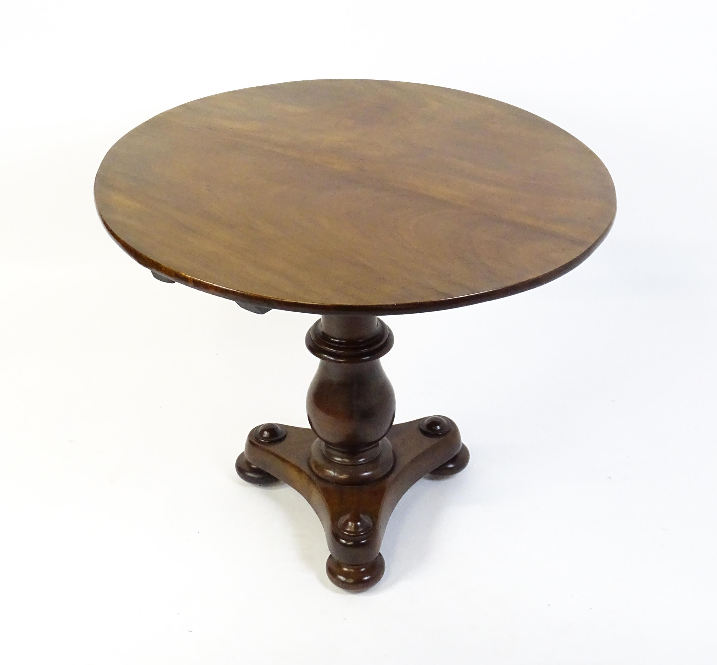 A late 19thC occasional table with a circular top above a turned pedestal and shaped base raised