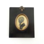 A 19thC silhouette portrait miniature depicting a young boy in profile, with gilt highlights.