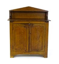 A 19thC simulated oak chiffonier with a pointed upstand above turned supports and two panelled doors