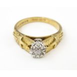 A 9ct gold ring set with central illusion set diamond with star detail to shoulders. Ring size