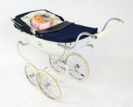 Toys: A 20thC Silver Cross dolls pram with cream exterior. Together with a plastic doll with