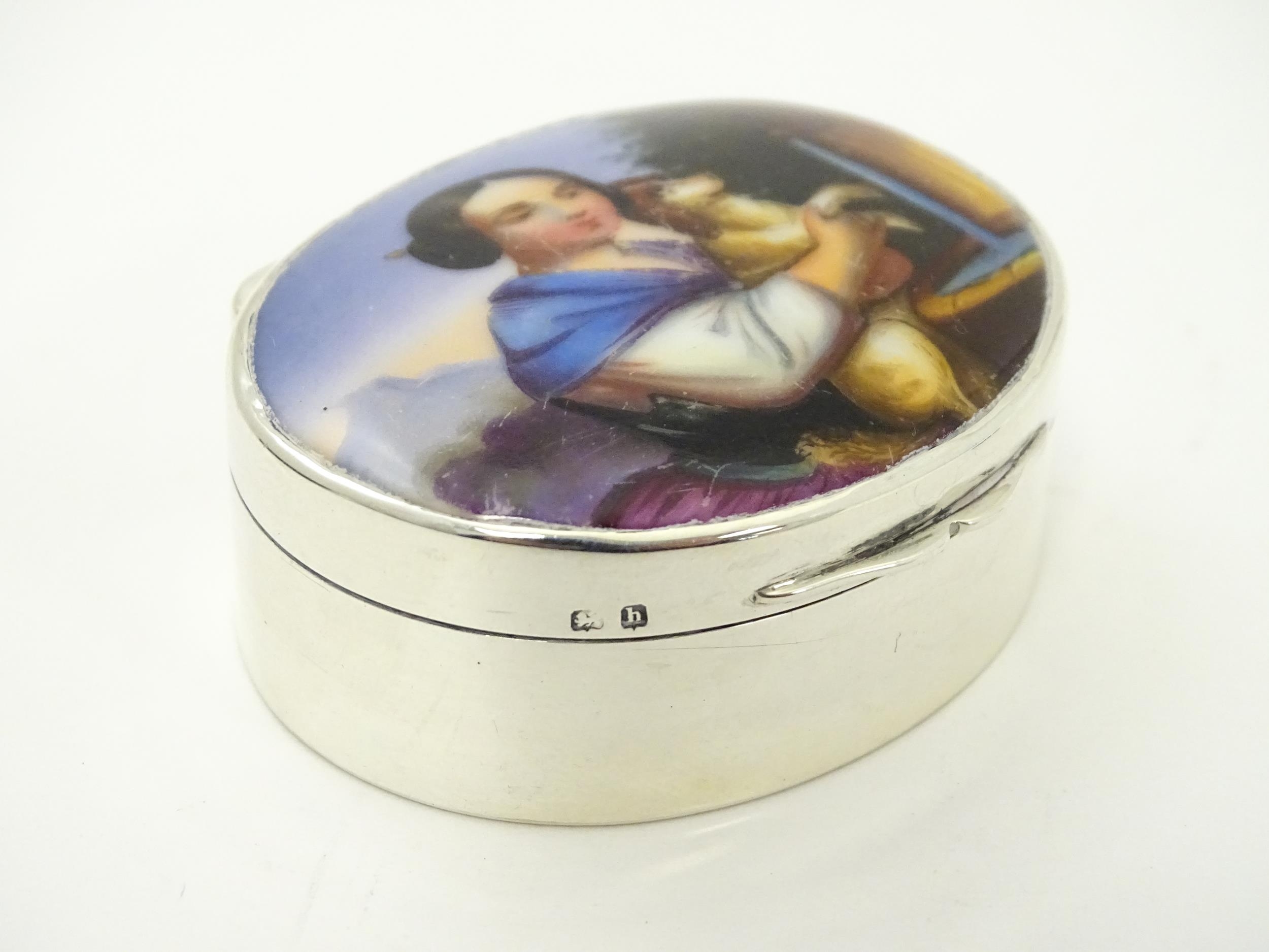 A silver pill box with gilded interior and ceramic cabochon to lid depicting a young girl holding - Image 2 of 9