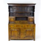 A mid 18thC oak dresser with a moulded cornice above three graduated shelves flanked by panelled
