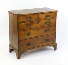 A late Georgian fruitwood chest of drawers comprising two short over three long drawers raised on