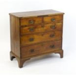 A late Georgian fruitwood chest of drawers comprising two short over three long drawers raised on