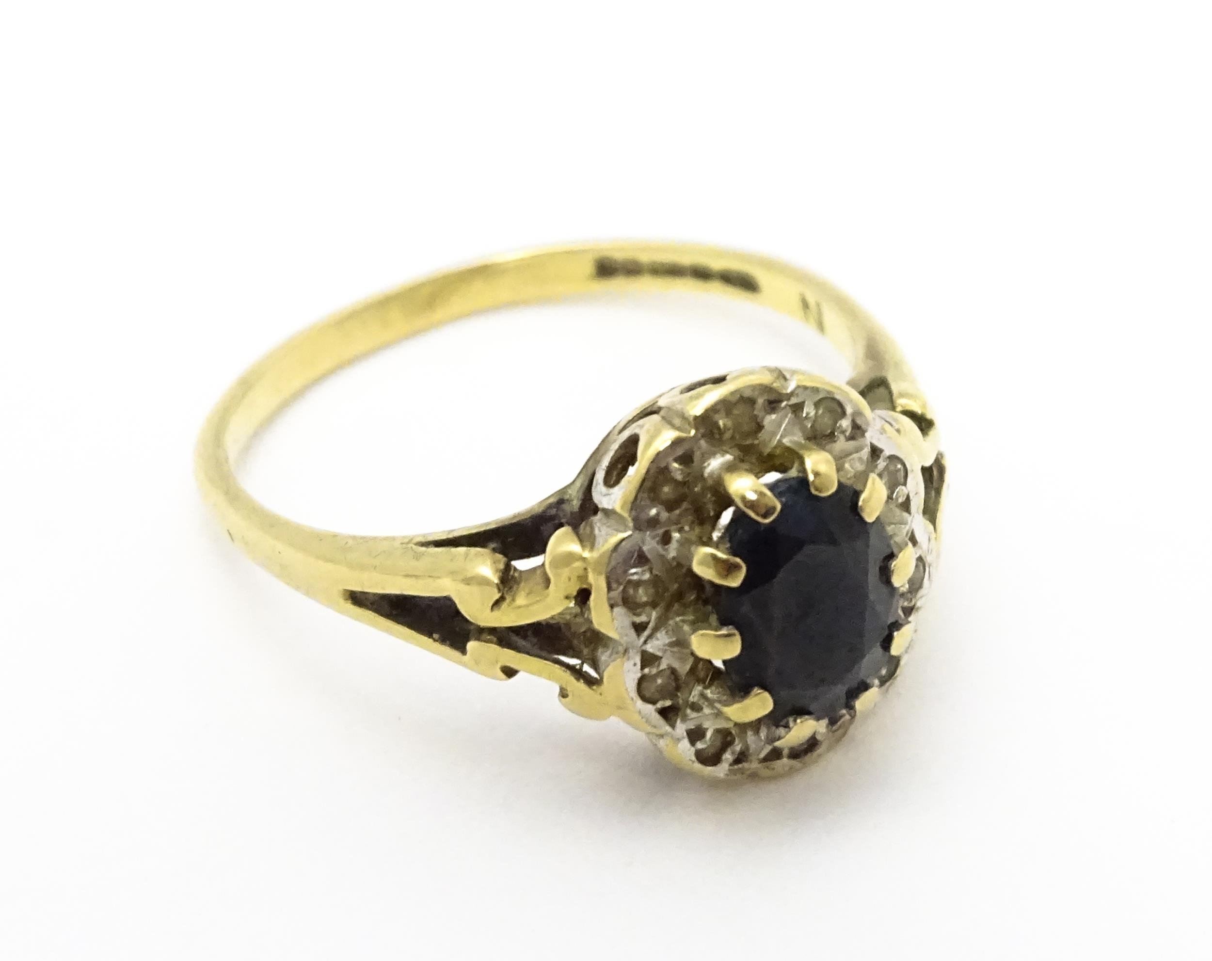 A 9ct gold ring set with central sapphire bordered by diamonds. Ring size approx. L 1/2 Please - Image 5 of 10