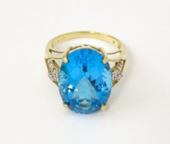 A 9ct gold cocktail ring set with large topaz flanked by diamonds. The stone approx 3/4" long.