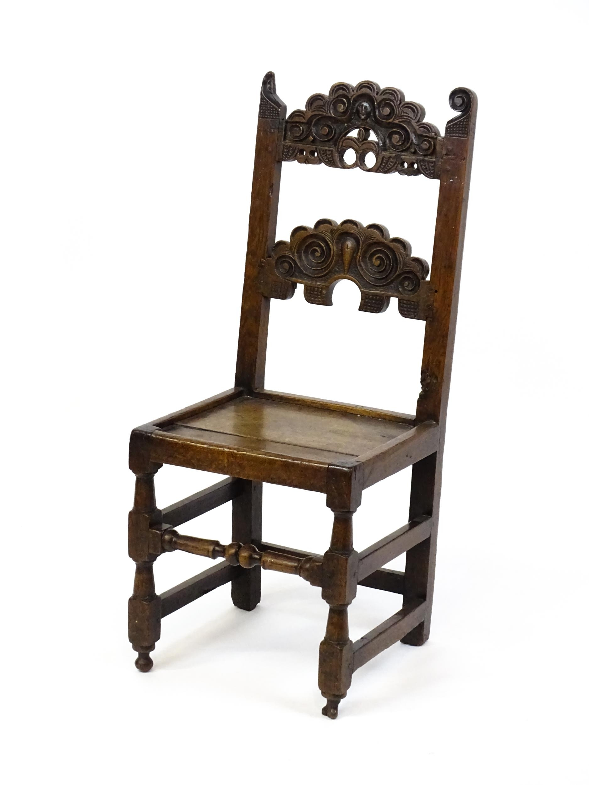 A 17thC oak peg jointed hall chair / back stool with a carved and scrolled top and mid rail raised - Image 4 of 7